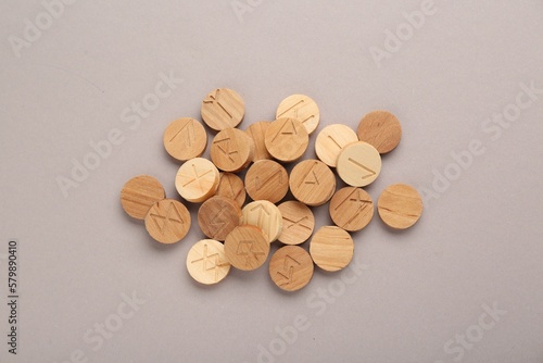 Pile of wooden runes on light grey background, flat lay