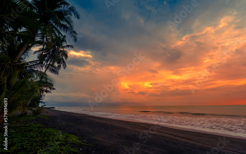 Beautiful tropical seascape, sunset at beach with colorful sky © Johnster Designs