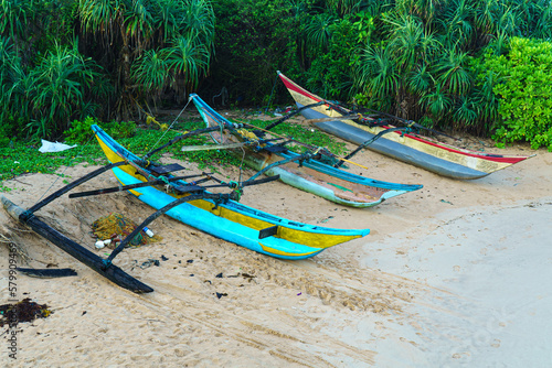 Three fishing boats on the sandy beach of Sri Lanka