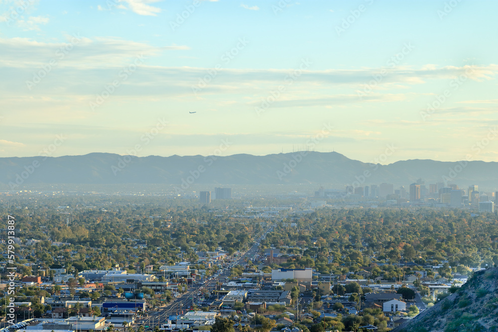 Obraz premium Evening above distant downtown skyscrapers, buildings and residential houses between South and North mountains known as Valley of The Sun, Phoenix, AZ