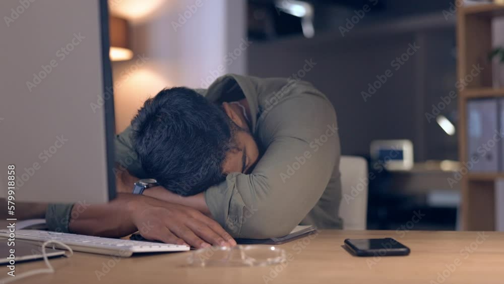 Tired, burnout and a business man sleeping at his desk while working late at night in his office at work. Exhausted, overtime and overworked with a male employee taking a break or nap in a workplace Tired, burnout and a business man sleeping at his desk while working late at night in his office at work. Exhausted, overtime and overworked with a male employee taking a break or nap in a workplace