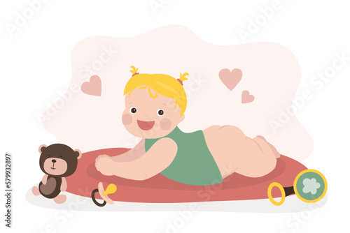 Baby girl lying on belly and playing. Cute infant lie on tummy. Caucasian newborn child. Happy small girl.