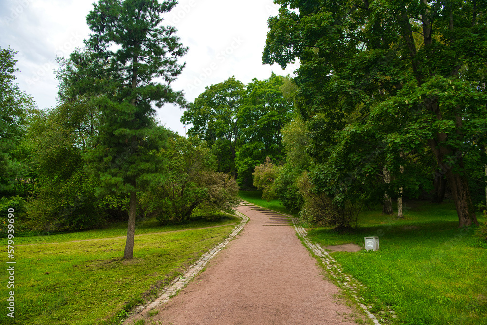 Path in green meadow and trees in Park Mon Repos, Vyborg, Russia