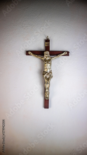 a cross hung on a white wall