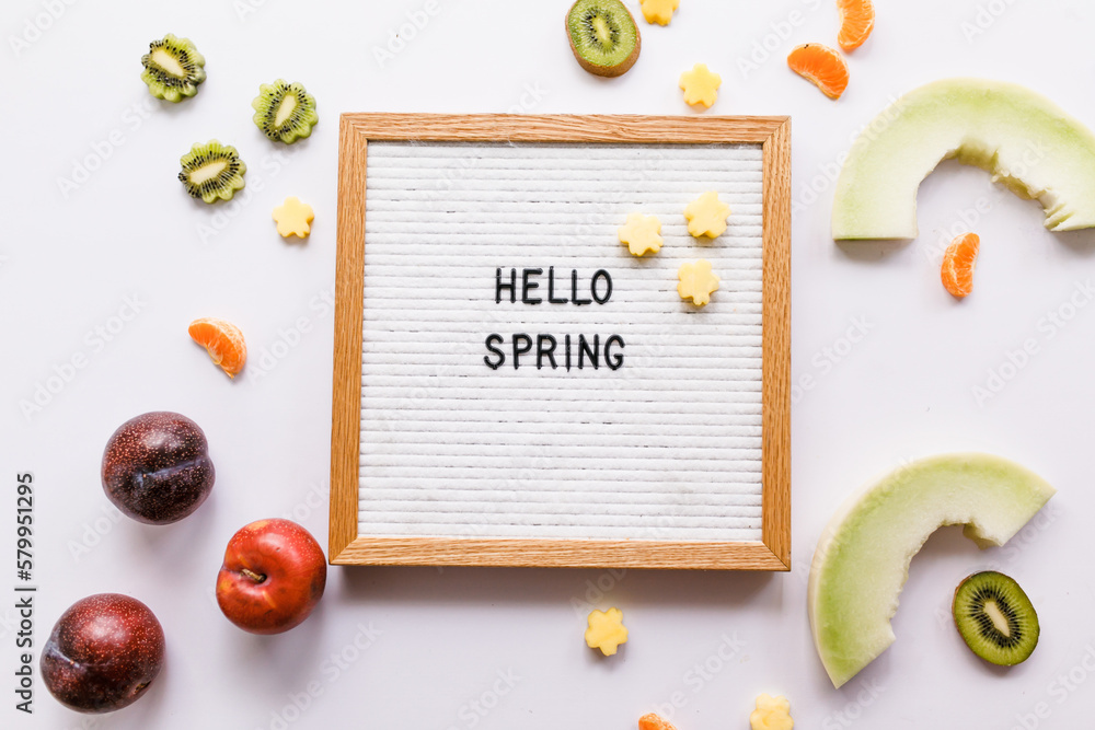 Hello Spring quote letter board with bright slices of fresh fruit Hello Spring quote letter board with bright slices of fresh fruit