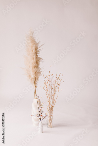 All white floor and wall with three vases of neutral pampas grass