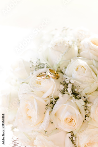 goldene Eheringe auf weißen Rosen bei Hochzeit
