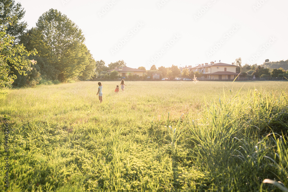 wide angle view on three children running in the field wide angle view on three children running in the field