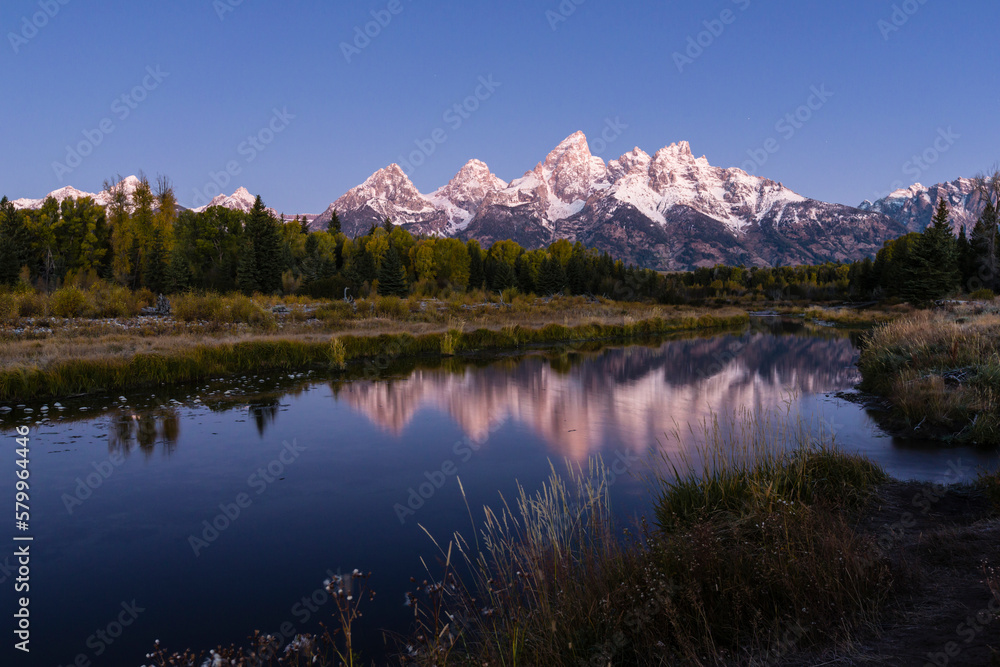 Scenic view of Lake by trees against clear sky at Grand Teton National Park during sunset Scenic view of Lake by trees against clear sky at Grand Teton National Park during sunset