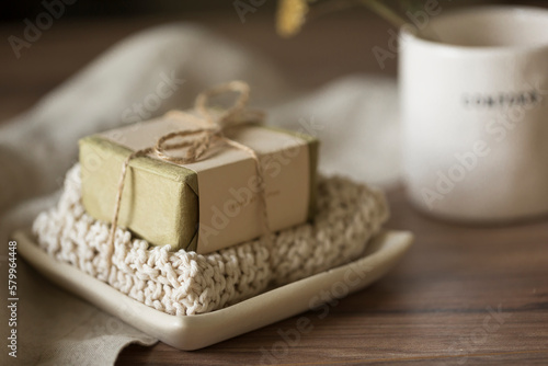 Close-up of soap with fabric in plate by drink on wooden table