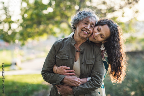 Daughter embracing mother while standing at park