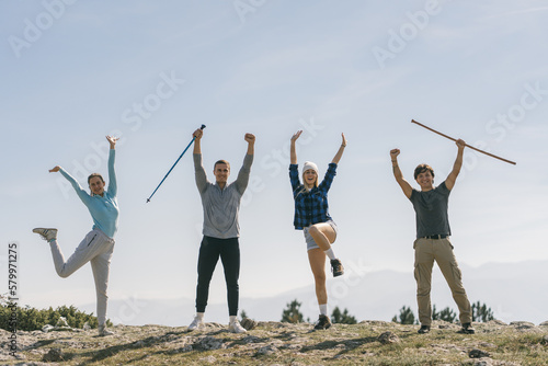 Happy friends with hands and hiking sticks up