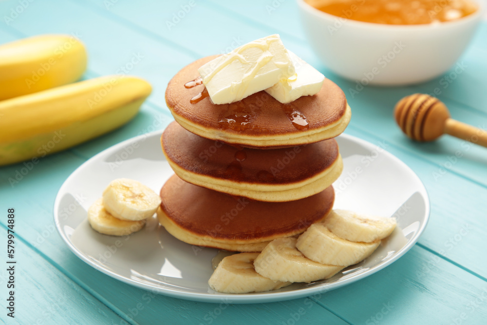 Plate with yummy banana pancakes on blue background. Plate with yummy banana pancakes on blue background.