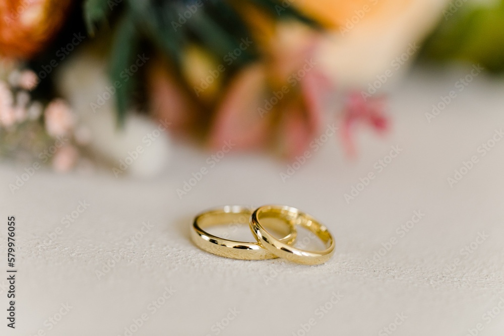 Goldene Eheringe vor Brautstrauß Goldene Eheringe vor Brautstrauß