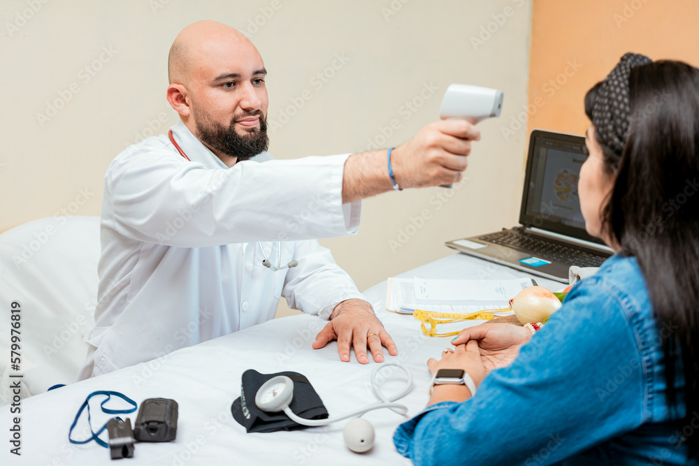 Doctor measuring temperature with infrared gun to female patient ...