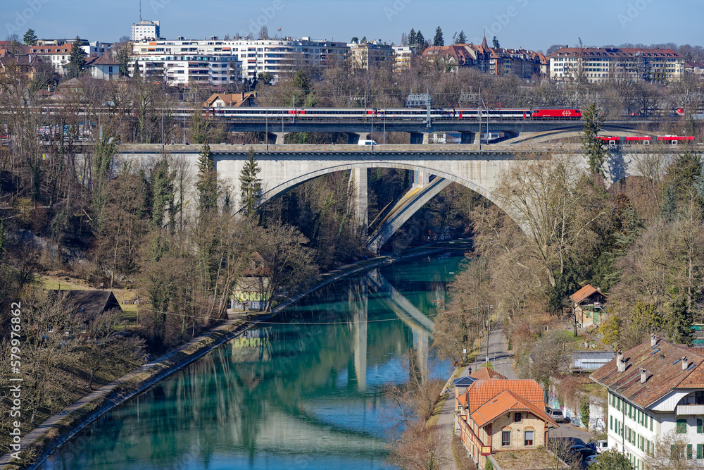 Bridges over Aare River with bus and train crossing at Swiss City of Bern on a sunny winter day. Photo taken February 21st, 2023, Bern, Switzerland.