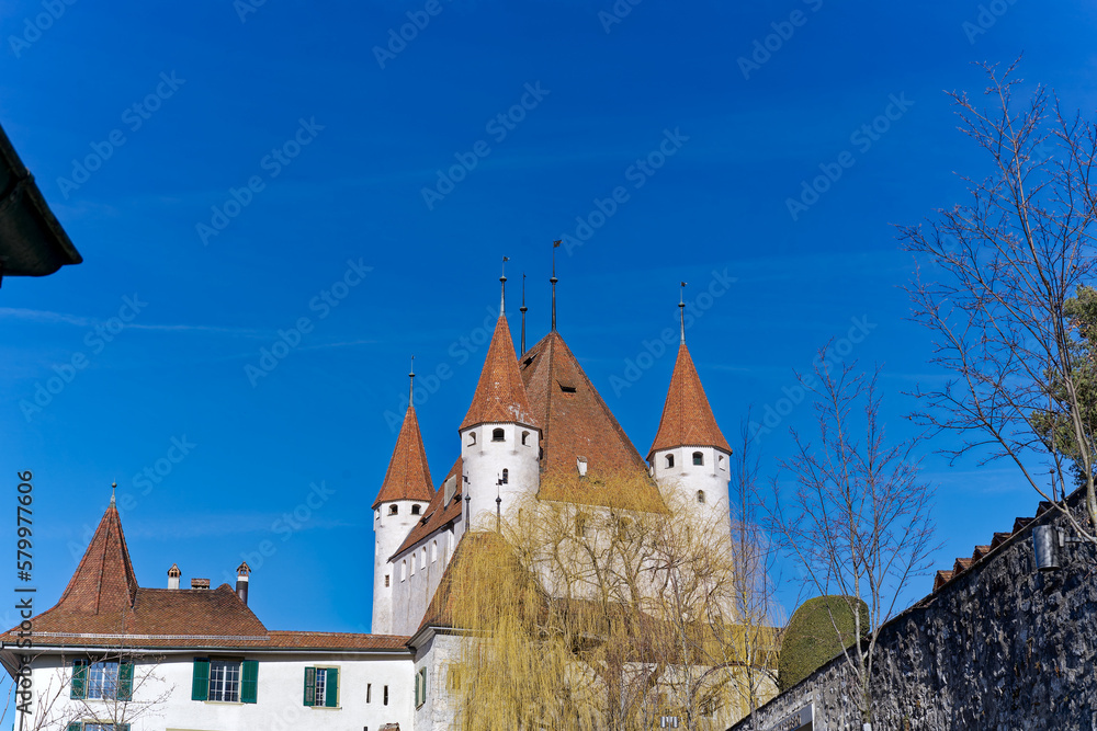 City of Thun with close-up of white castle on a hill in the background on a sunny winter day. Photo taken February 21st, 2023, Thun, Switzerland.