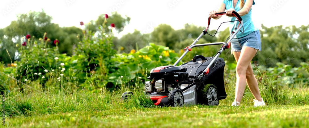 a girl mows the lawn with a lawn mower a girl mows the lawn with a lawn mower