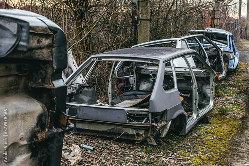 A dump of broken rusted cars, their parts and tires