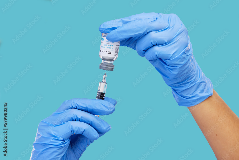 Mockup, closeup and hands with needle, vial and vaccination for diagnosis against a blue studio background. Zoom, hands and gloves, with medicine, cure and vaccination for medical diagnosis or result Mockup, closeup and hands with needle, vial and vaccination for diagnosis against a blue studio background. Zoom, hands and gloves, with medicine, cure and vaccination for medical diagnosis or result
