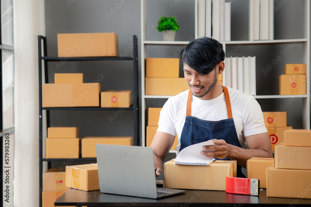An Asian man owns an online store, he is an internet store operator selling products through an online shopping platform. The concept of selling goods and services on the internet. An Asian man owns an online store, he is an internet store operator selling products through an online shopping platform. The concept of selling goods and services on the internet.