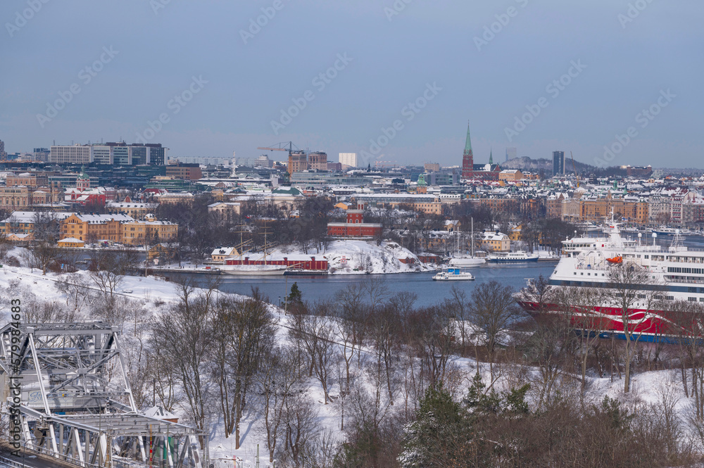 Harbor view, arriving ferry and commuting ferry, down town skyline, a snowy day in Stockholm