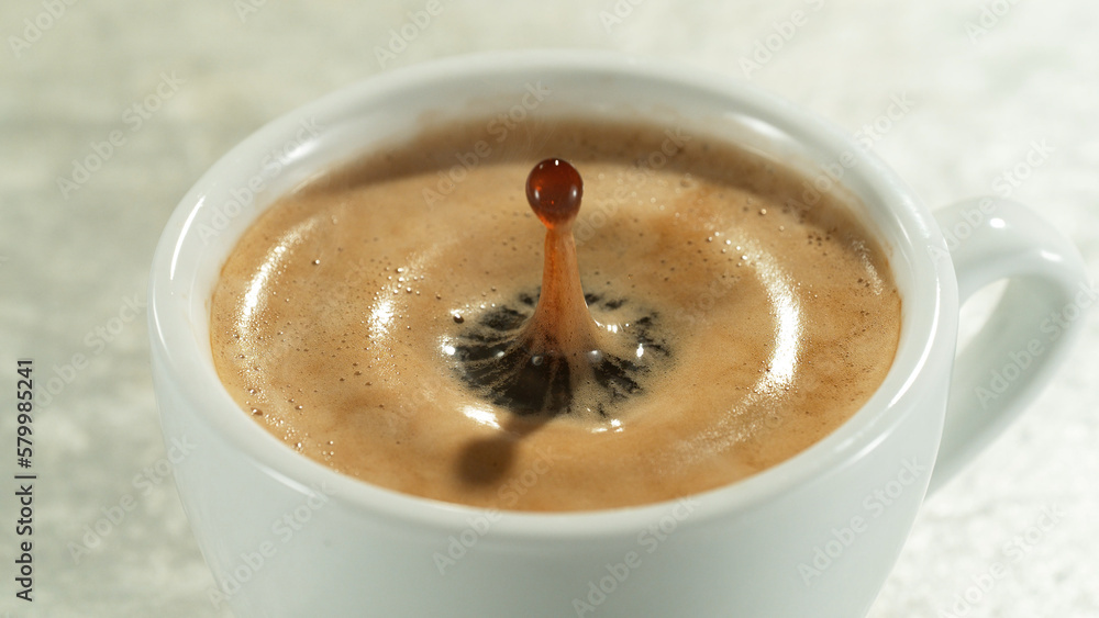 Detail of pouring whiskey into glass with ice cubes.