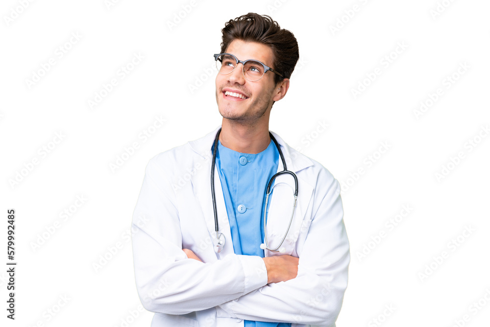 Young doctor man over isolated background looking up while smiling Young doctor man over isolated background looking up while smiling