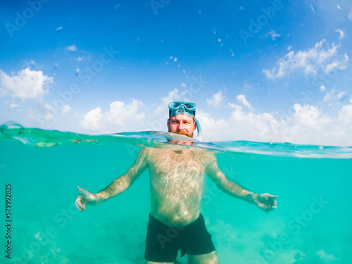 man snorkeling in crystal clear tropical sea © Melinda Nagy