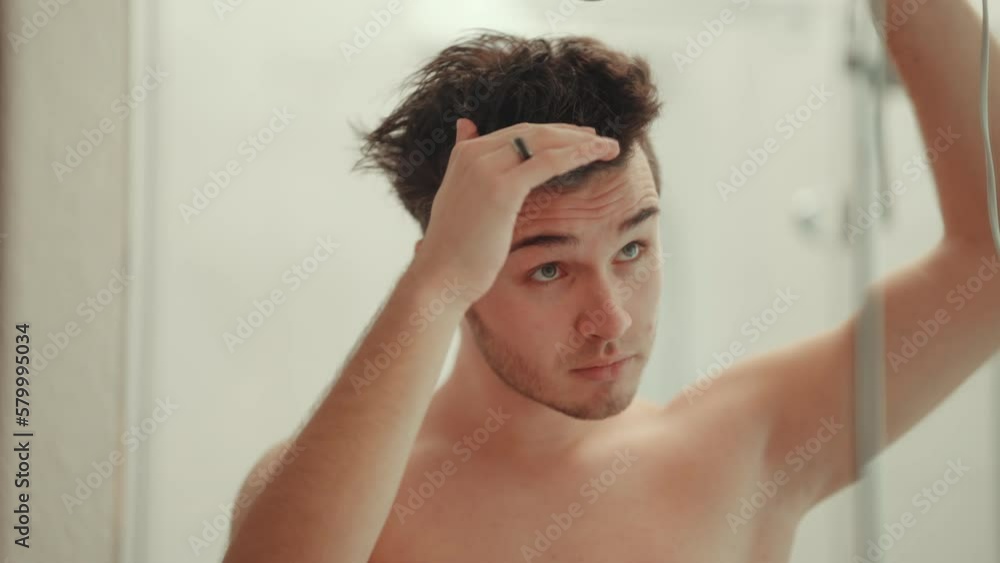 Man blow-drying his hair in the bathroom. Man blow-drying his hair in the bathroom.
