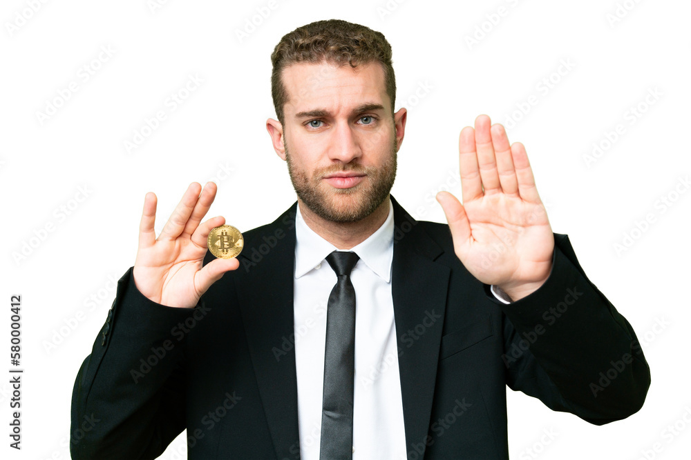 Young business blonde man holding a Bitcoin over isolated chroma key background making stop gesture Young business blonde man holding a Bitcoin over isolated chroma key background making stop gesture