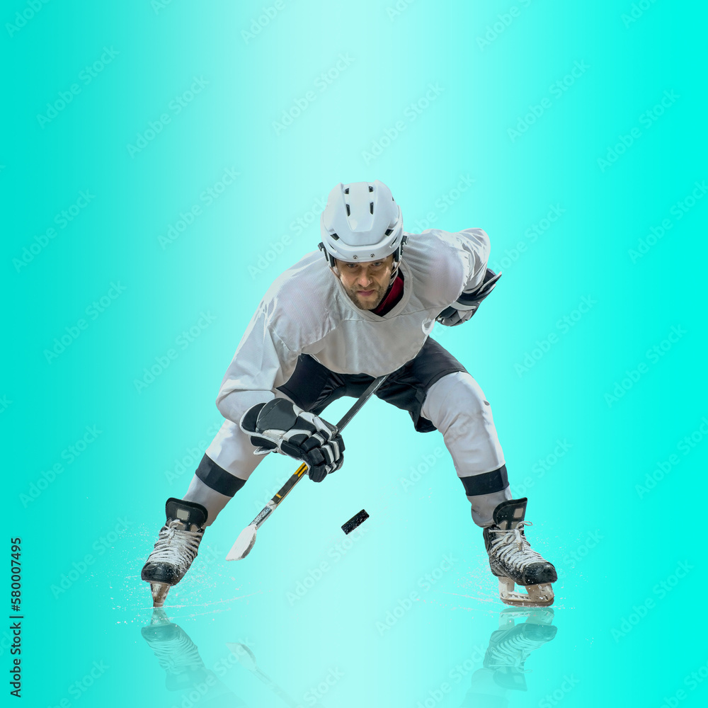 Professional ice hockey player hitting puck for winning goal in action on gradient multicolored neon background. Concept of sport competition. Professional ice hockey player hitting puck for winning goal in action on gradient multicolored neon background. Concept of sport competition.