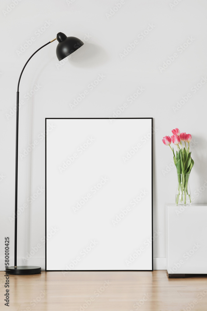 Blank picture frame mockup on white wall. White living room design. View of modern scandinavian style interior with artwork mock up standing on floor. Home staging and minimalism concept - obrazy, fototapety, plakaty 