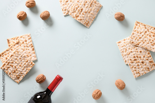 Matzah, red kosher and walnut traditional ritual Jewish bread in plate on blue background with copy space. Pesach Jewish holiday. Passover food and celebration concept. View from above.