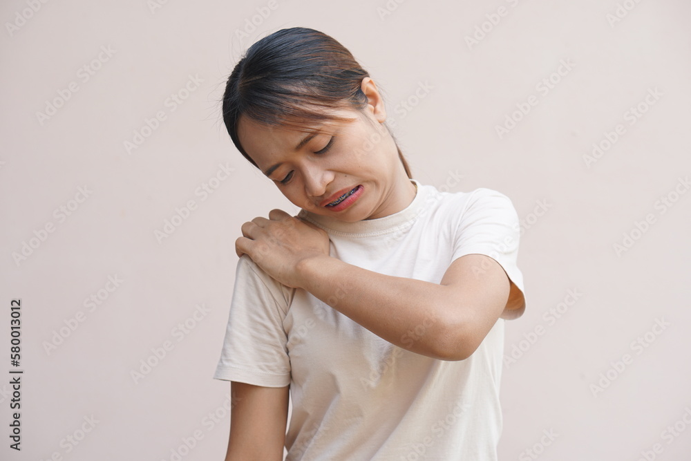 Asian woman suffering from shoulder pain from sitting for a long time at work Asian woman suffering from shoulder pain from sitting for a long time at work