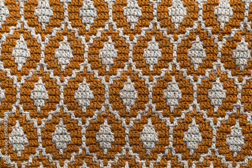 Yellow white mosaic crochet texture. Ellipse shaped repeating pattern. Knitted background.