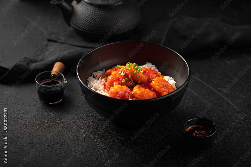 Portion of asian sweet and sour shrimp with rice on black background Portion of asian sweet and sour shrimp with rice on black background