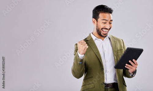 Businessman, tablet or success fist on isolated studio background for financial growth, stock market deal or mock up security. Smile, happy or cheering asian man with winner hands, technology or loan