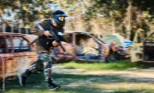Man, paintball and rush for intense battle or war in the forest running to attack on grass field. Male paintballer or soldier moving fast to push enemy defense in extreme adrenaline sports outdoors