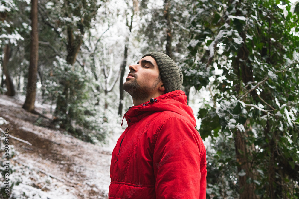 Young man in warm clothes standing in forest Young man in warm clothes standing in forest