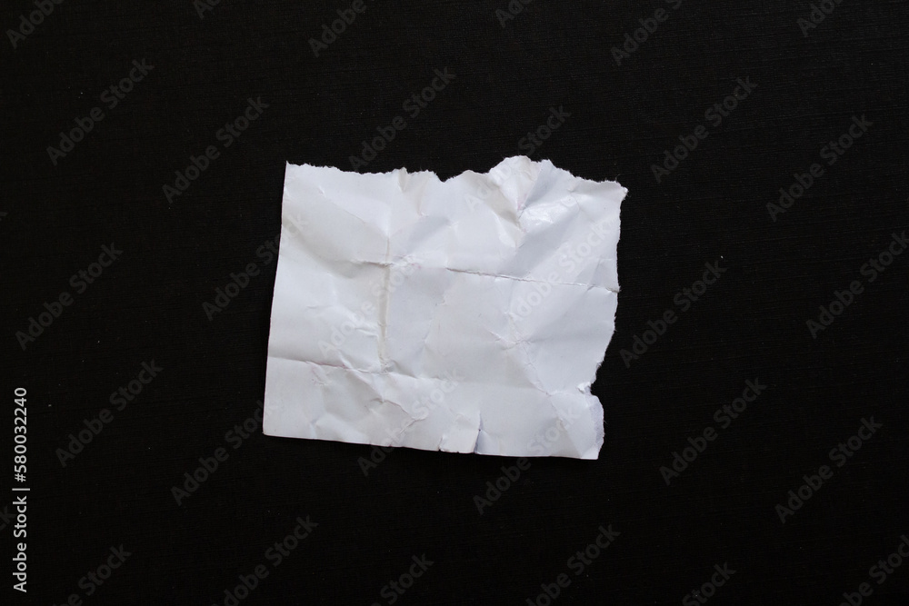 White crumpled torn paper piece isolated on black background White crumpled torn paper piece isolated on black background
