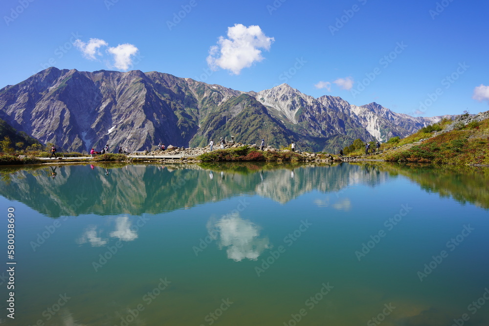 にぎわう秋の八方池と湖面に映る白馬三山