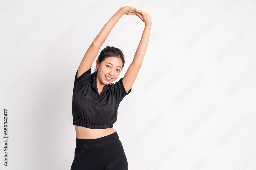 woman wearing black sportswear stretching hands raised on background isolated woman wearing black sportswear stretching hands raised on background isolated