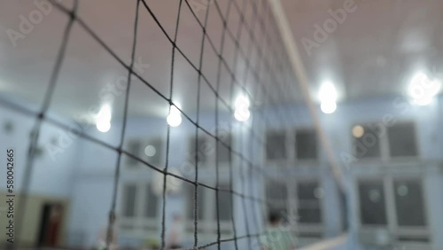 Gym, volleyball net close-up, soft focus. sports-themed volleyball net stretched in the gym, sports equipment ready for use. A volleyball net is hanging in a large gym inside. Horizontal video