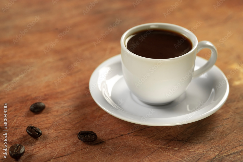 Coffee cup and coffee beans on wooden table. Black background. Coffee cup and coffee beans on wooden table. Black background.