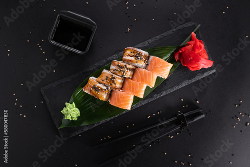 sushi roll with eel and salmon on a black stone board. Japanese cuisine. top view