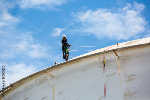 Wallpaper Mural Male worker down height tank roof rope access safety inspection thickness weld of storage tank. Torontodigital.ca