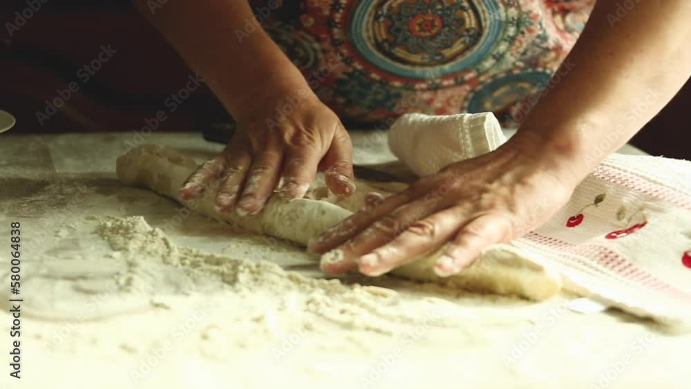 Home cooking of traditional Ukrainian cuisine. Vareniki with cherries close-up. A woman rolls out the dough with a rolling pin and sculpts dumplings.
Home cooking of traditional Ukrainian cuisine. Vareniki with cherries close-up. A woman rolls out the dough with a rolling pin and sculpts dumplings.