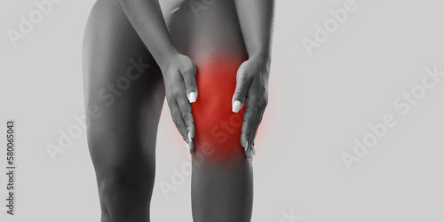 Crop close up white and black shot of unhealthy woman suffer from kneecap ache. Pain in knee concept. Unwell sick female struggle with leg problems, have osteoarthritis disease. Healthcare concept.