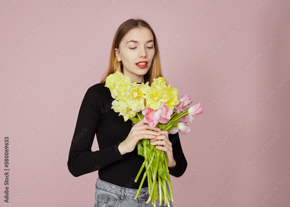 a happy woman with a bouquet of tulips poses on a pink background a happy woman with a bouquet of tulips poses on a pink background